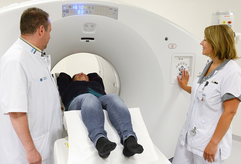 Een patiënt schuift een PET/CT-scanner van de nieuwste generatie in het Catharina Ziekenhuis, begeleid door twee zorgmedewerkers.