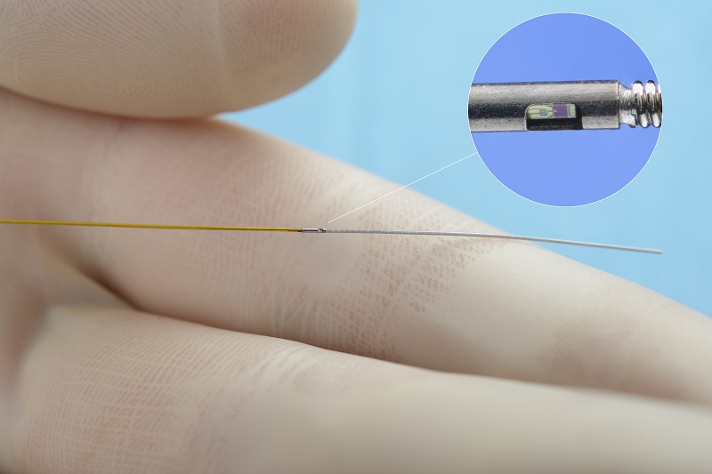 Een gehandschoende hand houdt een dun medisch instrument met sensor, gebruikt bij dotteronderzoek in het Catharina Ziekenhuis.