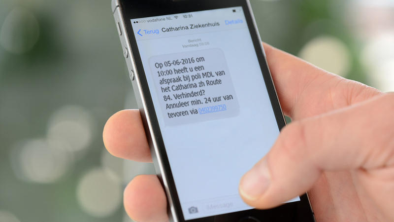 Hand houdt smartphone met Nederlandse tekst over afspraak Catharina Ziekenhuis, annuleerinstructies en telefoonnummer.