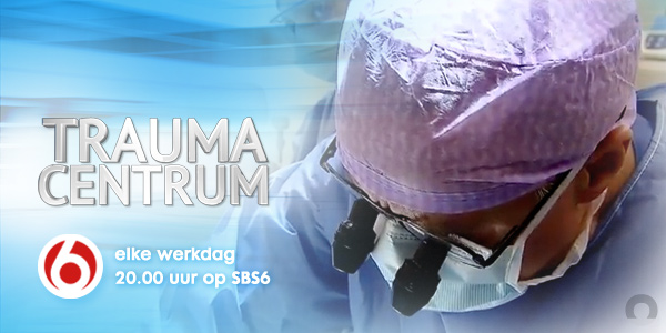 Chirurg met paarse muts en bril in close-up, tekst: TRAUMA CENTRUM, werkdagen 20:00 op SBS6, met SBS6-logo.