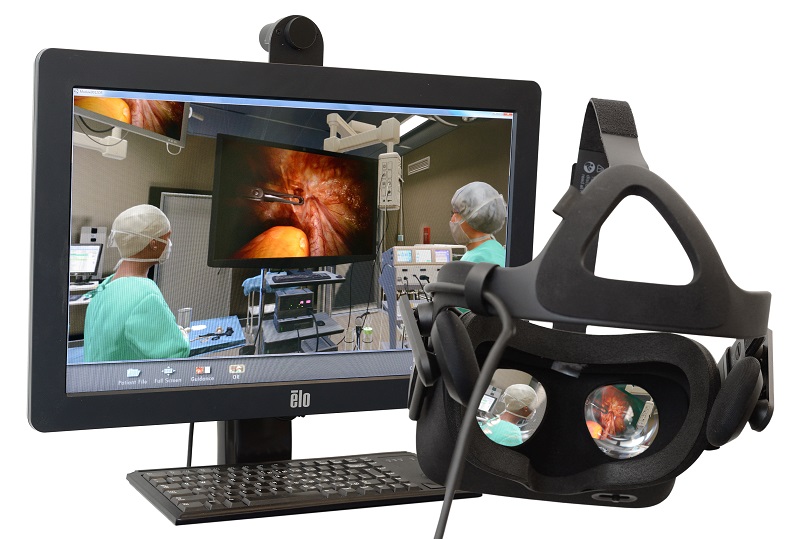 VR-bril voor monitor met operatiescène in Catharina Ziekenhuis, medisch team bezig; toetsenbord onder de monitor.