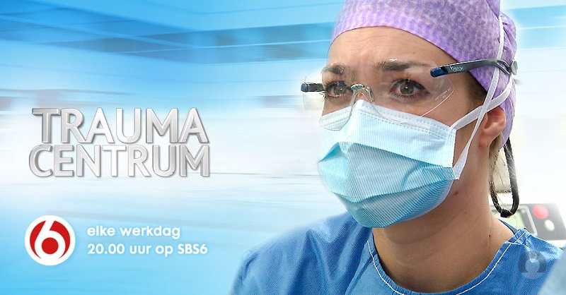Kunst met mondkapje en bril in ziekenhuis. Tekst: Trauma Centrum-waar elke maag telt, elke werkdag 20.00 uur op SBS6, rood SBS6-logo.