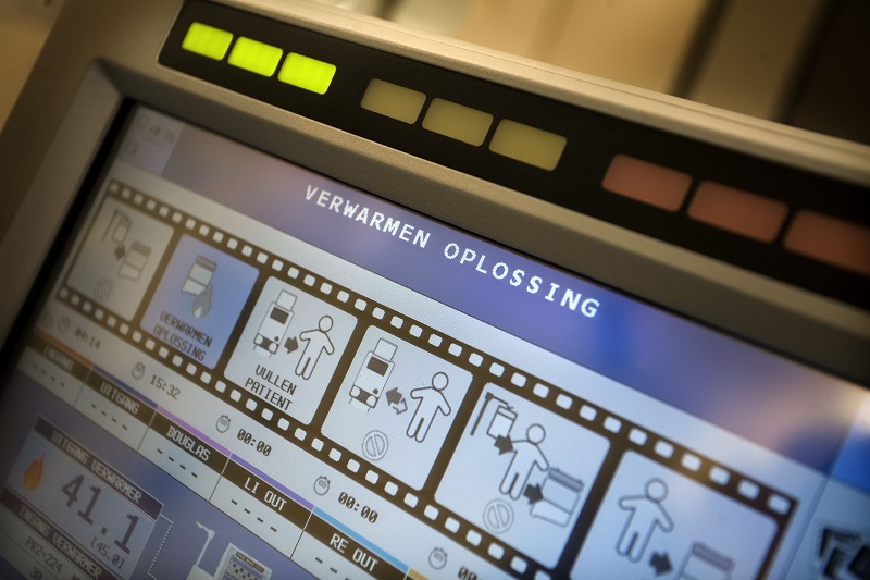 Close-up van een scherm met Nederlandse tekst, pictogrammen en knoppen over HIPEC-behandeling; bovenaan staat VERWARMEN OPLOSSING.