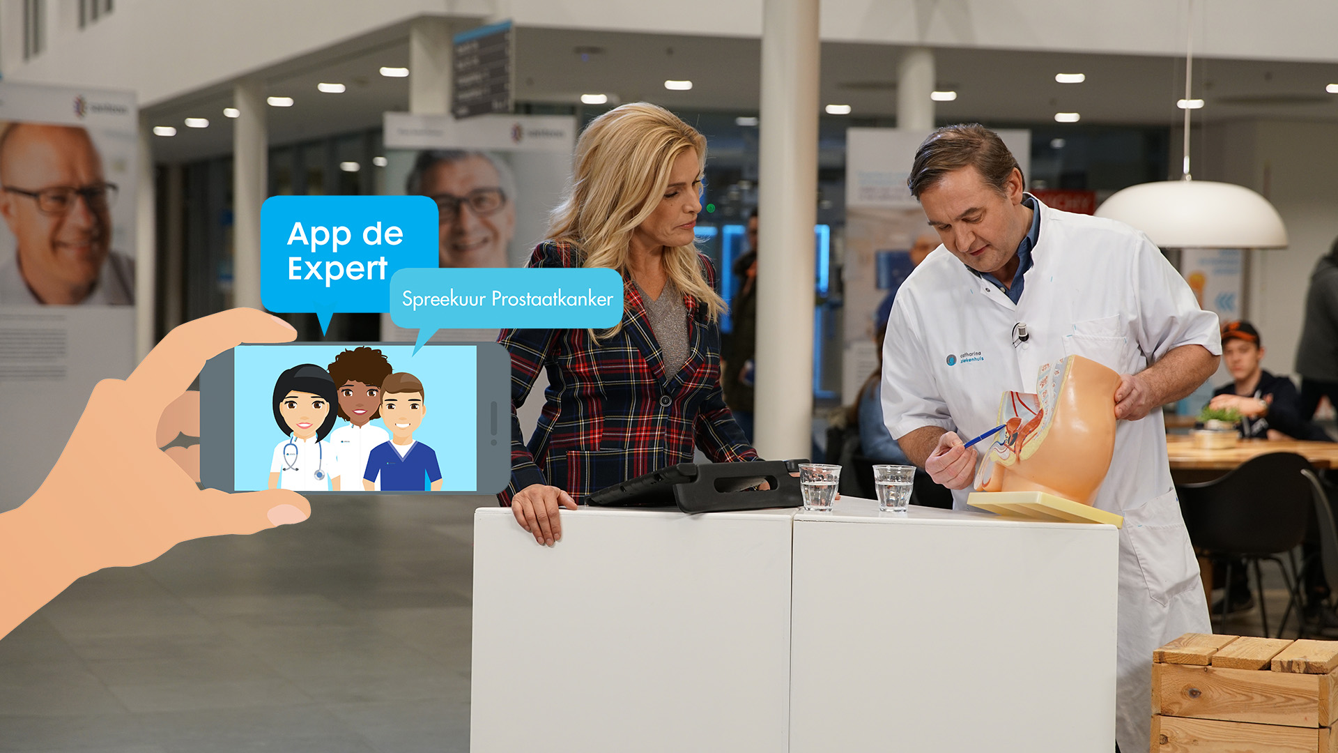 Een presentatrice en arts bespreken prostaatkanker met een medisch model, met tekst: "App de Expert Spreekuur Prostaatkanker".