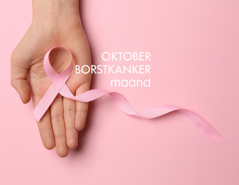 Een hand houdt een roze lintje vast. Lichtroze achtergrond met de tekst "Oktober Borstkanker maand" in beeld.