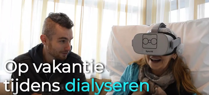 Een vrouw op een ziekenhuisbed draagt een VR-bril. Er zit een man naast haar. Tekst: "Op vakantie tijdens het dialyseren".