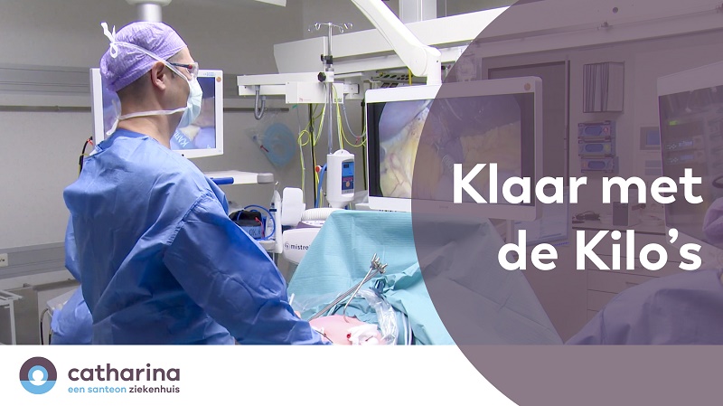 Een arts in blauwe OK-kleding staat bij een patiënt tijdens een operatie. Tekst: Klaar met de Kilo's Deel 6. Logo Catharina Ziekenhuis.