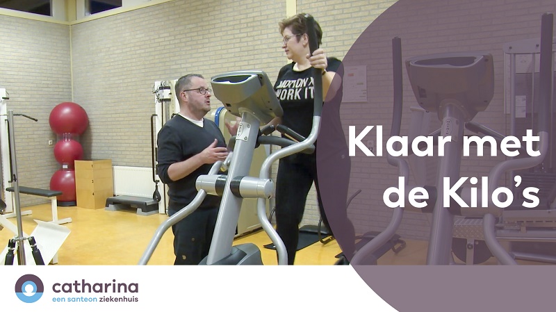 Een man en vrouw zijn in de sportschool; zij staan op een crosstrainer en hij praat. Tekst: "Klaar met de Kilo's.