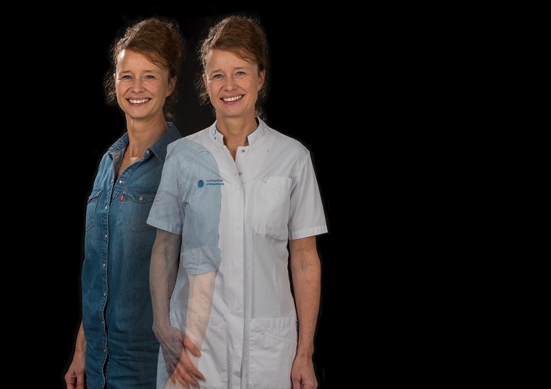 Een vrouw staat tegen een zwarte achtergrond in dubbele belichting: links in spijkerblouse, rechts in wit medisch uniform.