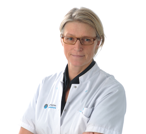 Persoon met kort blond haar en bril draagt een witte doktersjas en staat met gekruiste armen voor een witte achtergrond.
