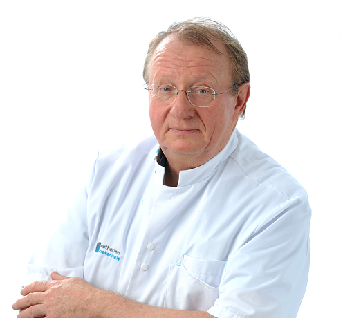 Oudere man met bril en witte doktersjas staat voor een witte achtergrond en kijkt neutraal in de camera.