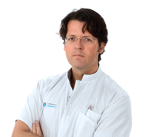 Man met bril en witte doktersjas, pennen op borstzak, staat met gekruiste armen en kijkt recht in de camera voor witte achtergrond.