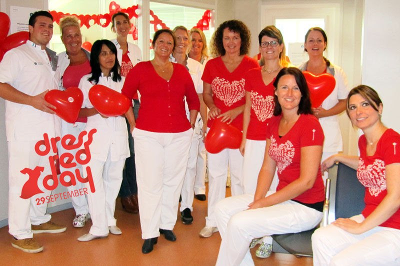 Groep vrouwen poseert binnen bij Catharina Hart- en vaatcentrum in rood-witte kleding met hartballonnen. Dress Red Day 29/9.