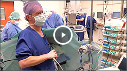 Een medisch team o.l.v. anesthesioloog Dick Koning werkt in OK; voorgrond houdt iemand chirurgische instrumenten vast.