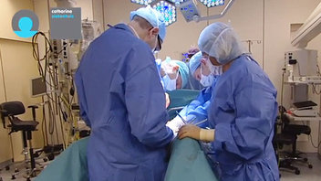 Medisch team in blauwe schorten opereert in een operatiekamer van het Trauma Centrum met medische apparatuur en lampen.