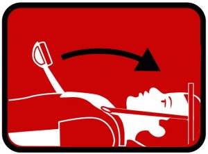 Illustratie van een persoon op het tapijt met hoofdimmobilisatie en halo-frame; een arm wordt omhoog getild, aangeduid met pijltje.
