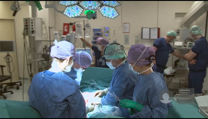 Chirurgen en medisch personeel voeren een operatie uit voor darmkanker in een helder verlichte operatiekamer.