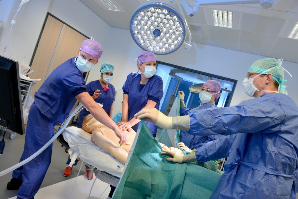 Medisch personeel voert een procedure uit op een pop in het Simulatiecentrum; één persoon doet hartmassage, anderen assisteren.