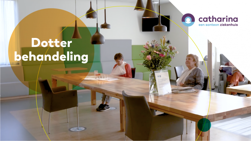 Twee vrouwen aan een houten tafel met bloemen en papieren in wachtruimte. Tekst en Catharina Ziekenhuis-logo in beeld.