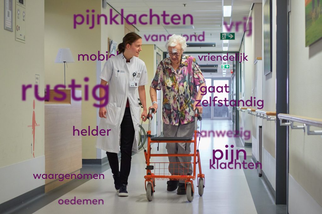 Zorgmedewerker loopt naast oudere vrouw met rollator in ziekenhuisgang. Paarse woorden als pijnklachten en mobiel staan in beeld.