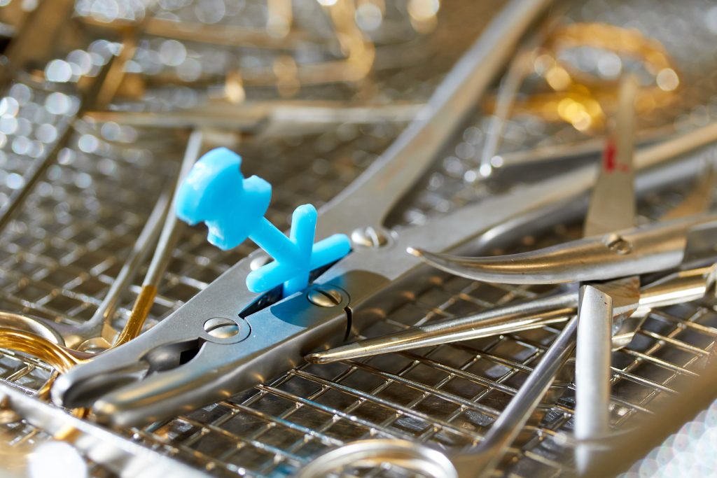 Close-up van chirurgische instrumenten, waaronder scharen en pincetten, op metalen schaal met blauw plastic hulpstuk in het Catharina Ziekenhuis.