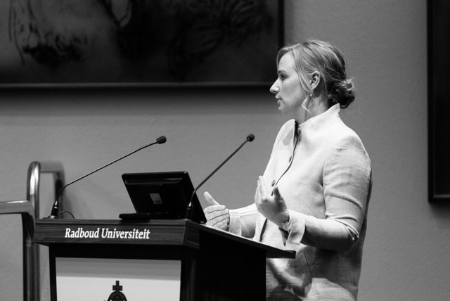 Een neuroloog spreekt bij een katheder van de Radboud Universiteit over het hielprikscreeningsprogramma voor pasgeborenen.