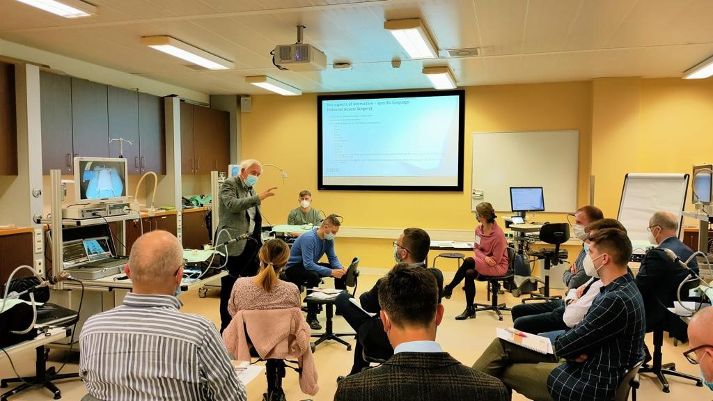 Poolse specialisten volgen een training in het Catharina Ziekenhuis, sommigen met mondkapje, terwijl een spreker presenteert.