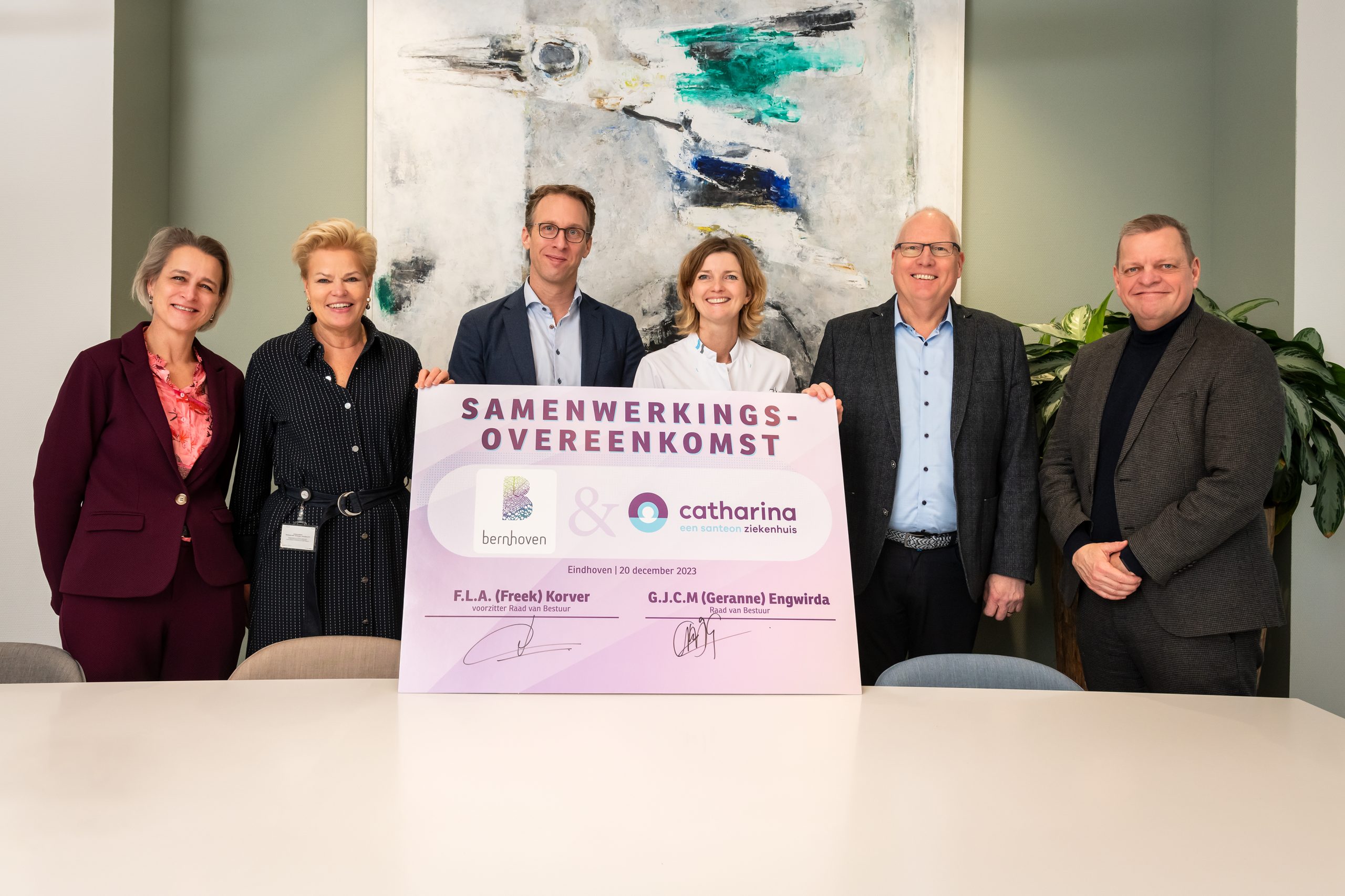 Zes mensen staan binnen achter een bord met 'Samenwerkingsovereenkomst' en de logo's van Bernhoven en Catharina Ziekenhuis.