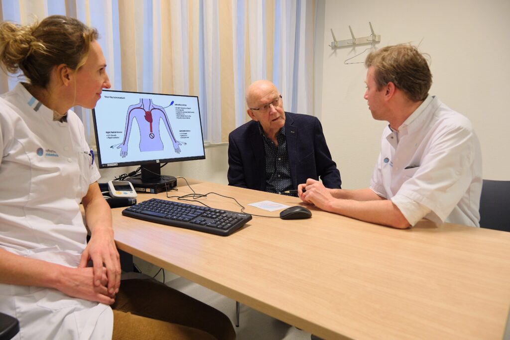 Meneer Van Gompel kon mooi nieuws brengen aan interventiecardiologen Pieter-Jan Vlaar en Inge Wijnbergen. Foto: Jarno Verhoef/Catharina Ziekenhuis 